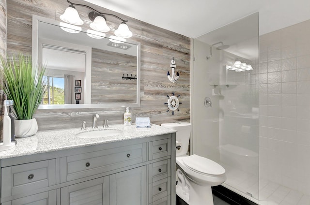 bathroom with vanity, tasteful backsplash, toilet, and walk in shower