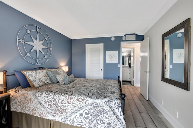 bedroom with hardwood / wood-style flooring, ornamental molding, and a closet