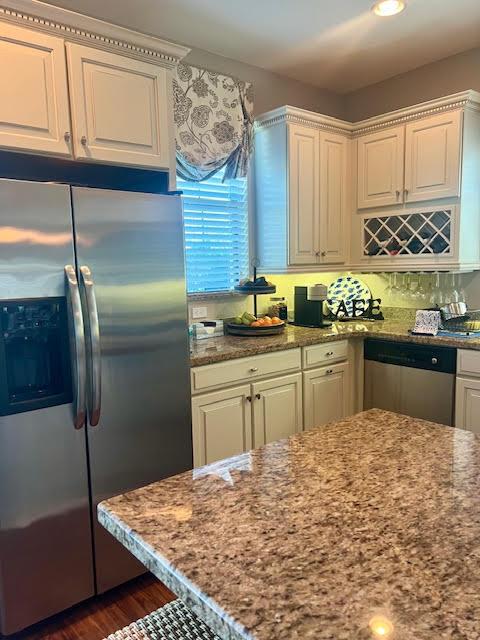 kitchen featuring stainless steel appliances, light stone countertops, and white cabinets