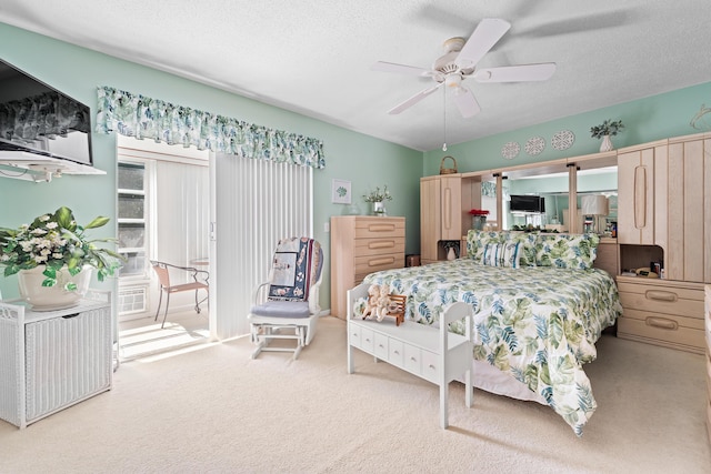 carpeted bedroom with ceiling fan and a textured ceiling