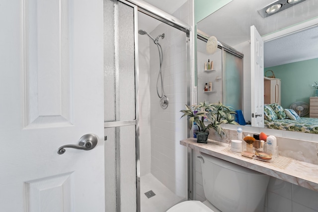 bathroom featuring toilet and a shower with shower door