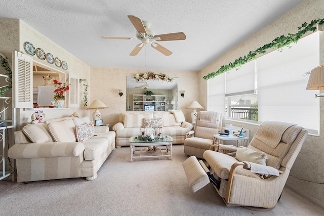 living room featuring ceiling fan, carpet flooring, and a textured ceiling