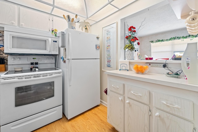 kitchen featuring light brown cabinetry, white appliances, and light hardwood / wood-style floors