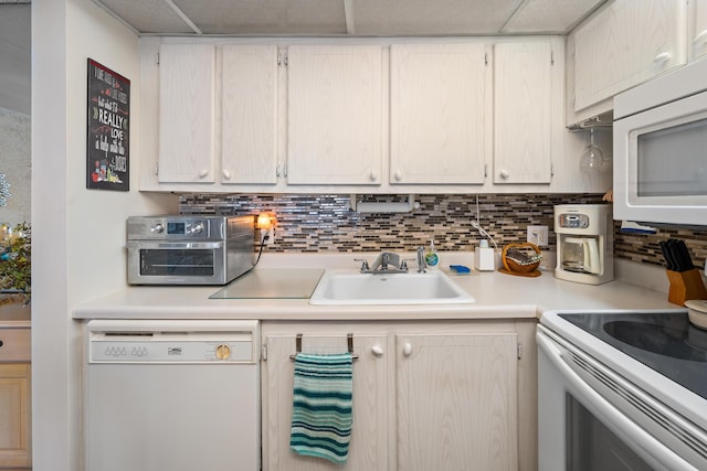 kitchen featuring tasteful backsplash, sink, and white appliances