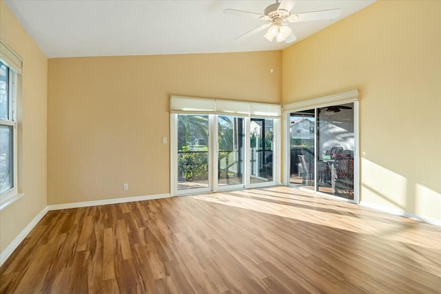 unfurnished room with ceiling fan, wood-type flooring, and a wealth of natural light