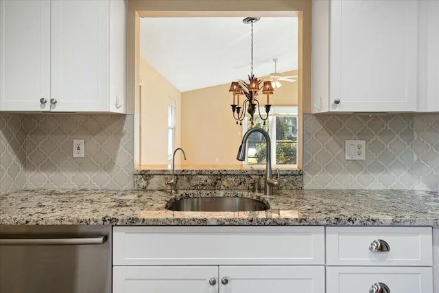 kitchen featuring dishwasher, vaulted ceiling, sink, and white cabinets