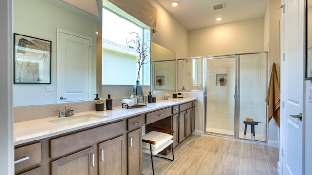 bathroom with vanity, wood-type flooring, and a shower with shower door