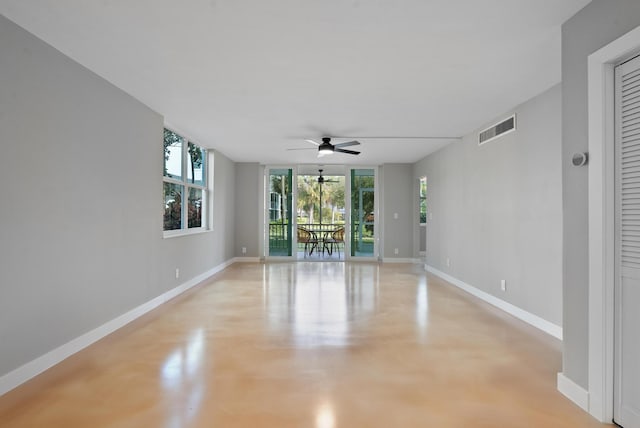 unfurnished room featuring ceiling fan and floor to ceiling windows