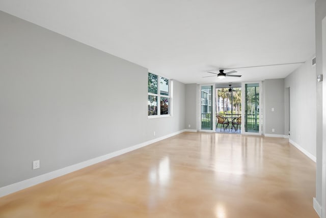 empty room featuring a wall of windows and ceiling fan