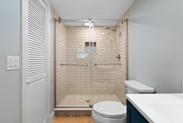 bathroom with walk in shower, vanity, and toilet