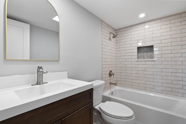 full bathroom featuring tiled shower / bath combo, vanity, and toilet