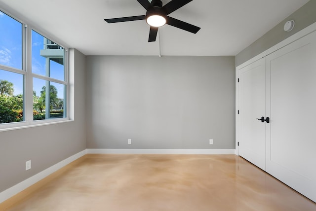 spare room featuring concrete floors and ceiling fan