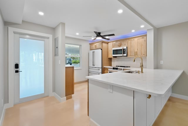 kitchen featuring sink, tasteful backsplash, high end white refrigerator, kitchen peninsula, and light brown cabinets