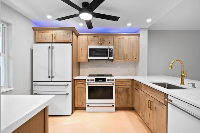 kitchen featuring sink, white appliances, ceiling fan, a wealth of natural light, and decorative backsplash