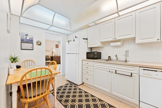 kitchen featuring sink, light tile patterned floors, backsplash, white appliances, and white cabinets