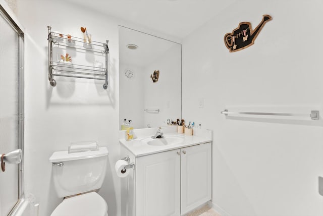 bathroom featuring walk in shower, vanity, and toilet