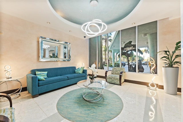 living room featuring a chandelier and a raised ceiling