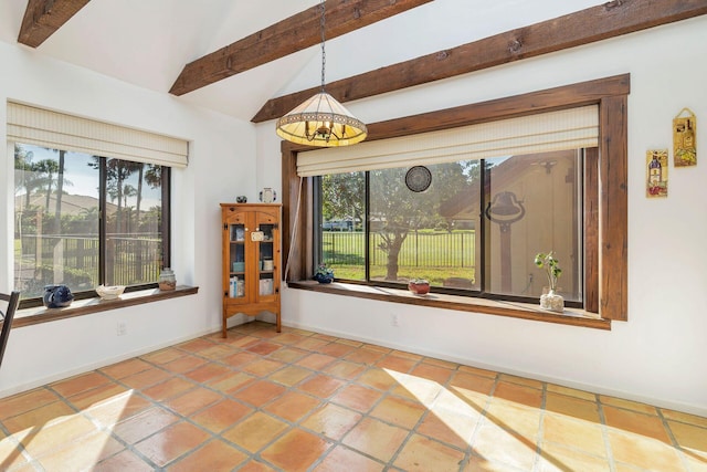 interior space featuring lofted ceiling with beams and tile patterned flooring