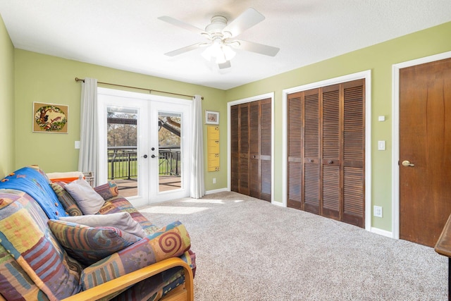 living area featuring carpet floors, ceiling fan, and french doors