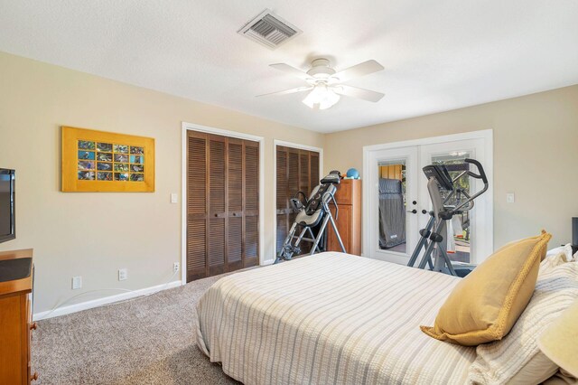 bedroom featuring multiple closets, carpet floors, and ceiling fan