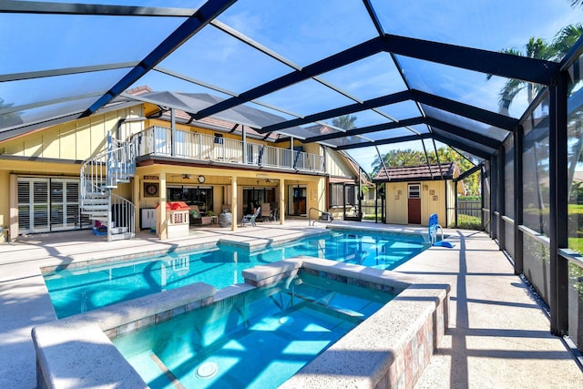 view of swimming pool featuring an in ground hot tub, a patio, and glass enclosure