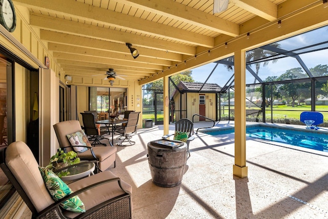 view of patio featuring ceiling fan and glass enclosure