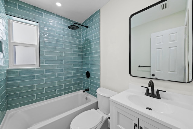 full bathroom with tiled shower / bath, vanity, and toilet