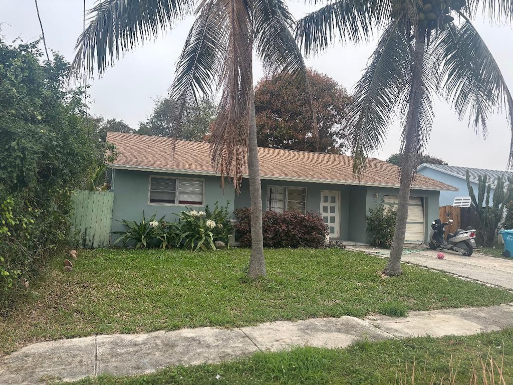 ranch-style home with a garage and a front yard