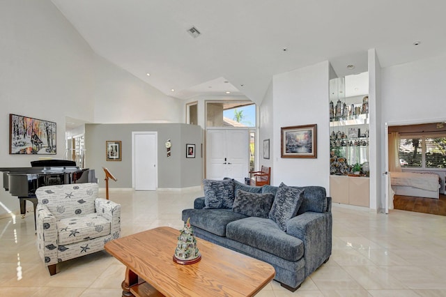 living room with light tile patterned floors and a towering ceiling