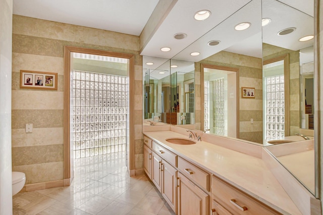 bathroom featuring vanity, tile walls, tile patterned floors, and toilet