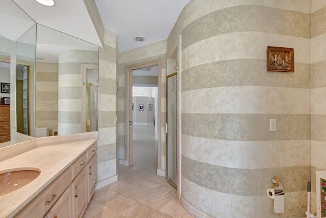 bathroom with vanity, a shower with shower door, and tile walls