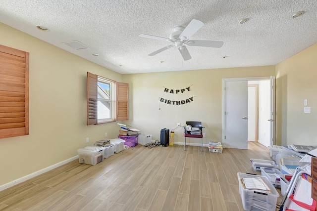 interior space with ceiling fan, light hardwood / wood-style flooring, and a textured ceiling