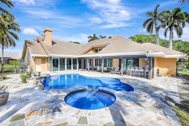 view of pool with an in ground hot tub, exterior bar, and a patio