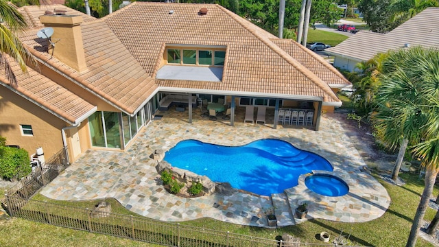 view of pool featuring a bar, an in ground hot tub, and a patio area