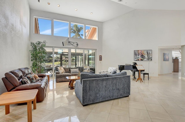 living room featuring a towering ceiling and plenty of natural light