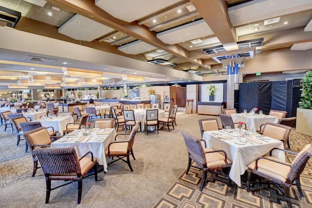 dining room featuring beam ceiling, a high ceiling, and carpet flooring