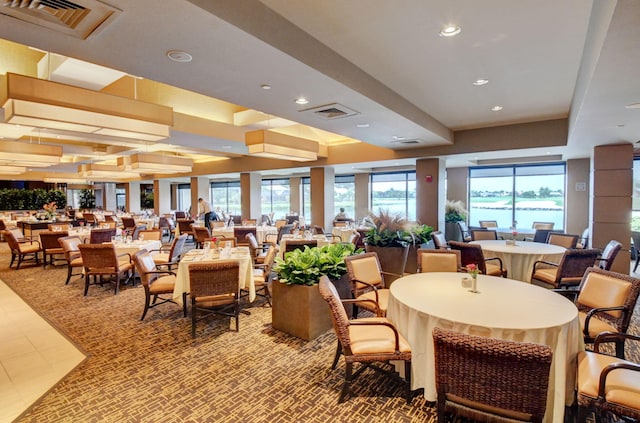 dining area with a water view and a tray ceiling