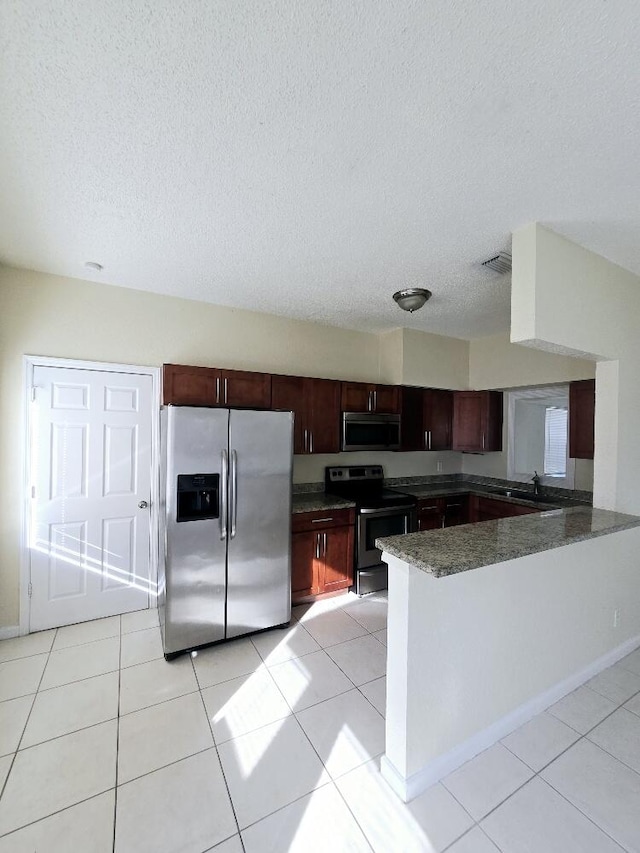 kitchen featuring stainless steel appliances, sink, light tile patterned floors, and kitchen peninsula