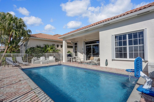 view of pool with ceiling fan, an outdoor living space, and a patio area