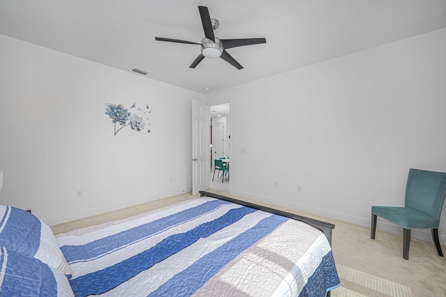 carpeted bedroom with baseboards, visible vents, ceiling fan, and a textured ceiling