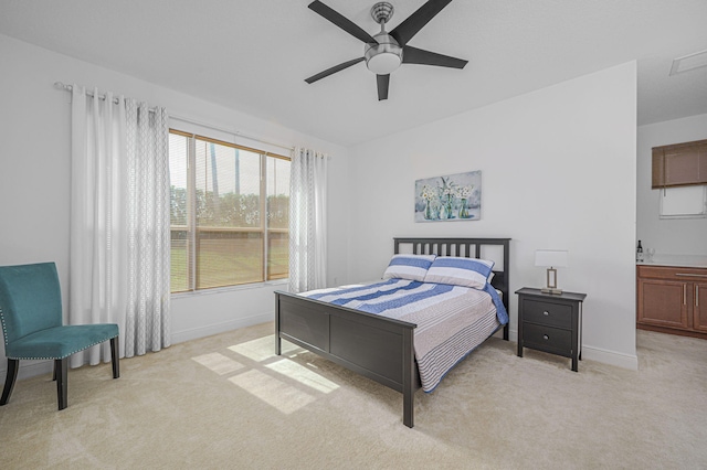 bedroom featuring light carpet, a ceiling fan, and baseboards