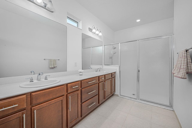 full bathroom with double vanity, tile patterned flooring, a sink, and a shower stall