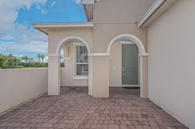 property entrance with a patio and stucco siding