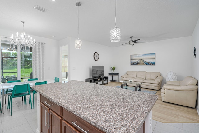 kitchen featuring pendant lighting, a center island, open floor plan, and visible vents