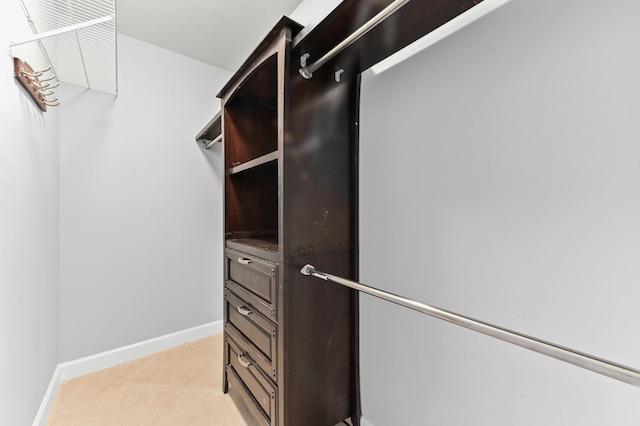 walk in closet with light tile patterned floors