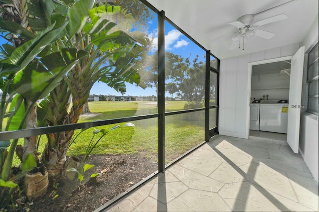 unfurnished sunroom with ceiling fan and washing machine and clothes dryer