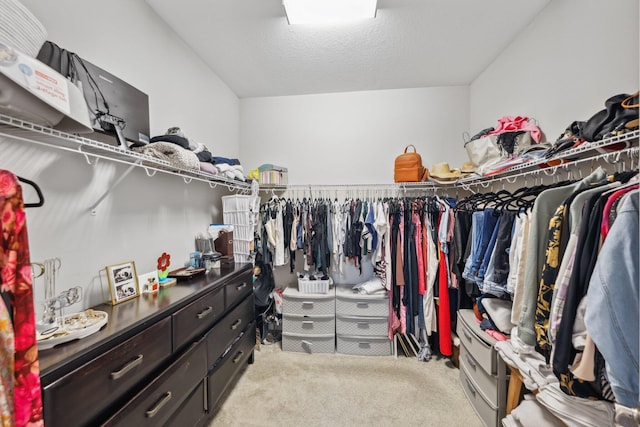 spacious closet featuring light carpet and lofted ceiling