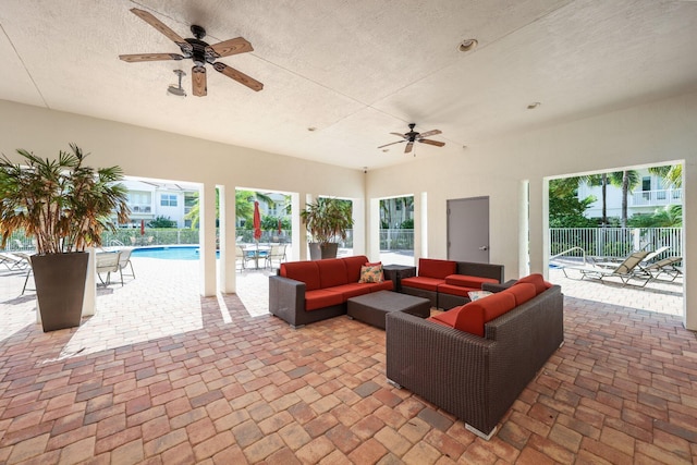 view of patio / terrace featuring ceiling fan, an outdoor hangout area, and a fenced in pool