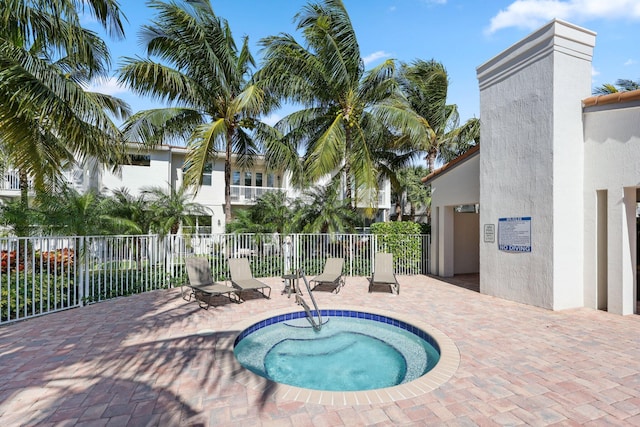 view of pool with a hot tub and a patio