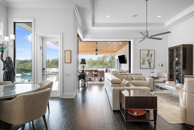 living room with dark wood-type flooring, ceiling fan, plenty of natural light, and crown molding